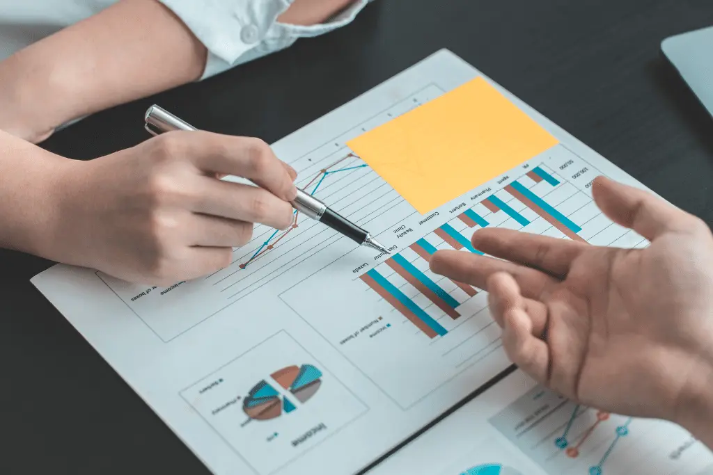 Zwei Personen besprechen ausgedruckte Diagramme mit Verkaufszahlen
