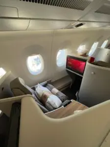 Business-Class-Sitz am Fenster mit bereitgelegtem Kissen und Decke