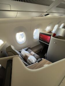 Business-Class-Sitz am Fenster mit bereitgelegtem Kissen und Decke