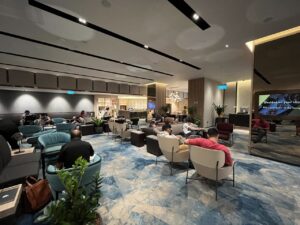 Gut besuchte Airport-Lounge mit Sesseln und wartenden Gästen